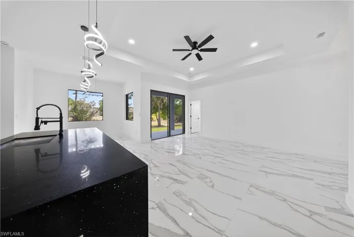 Kitchen view of stainless steel appliances, white cabinets, dark stone counters, and modern cabinets