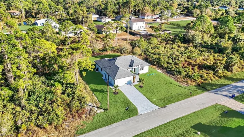 Prairie-style house featuring a front lawn, stucco siding, roof with shingles, and driveway