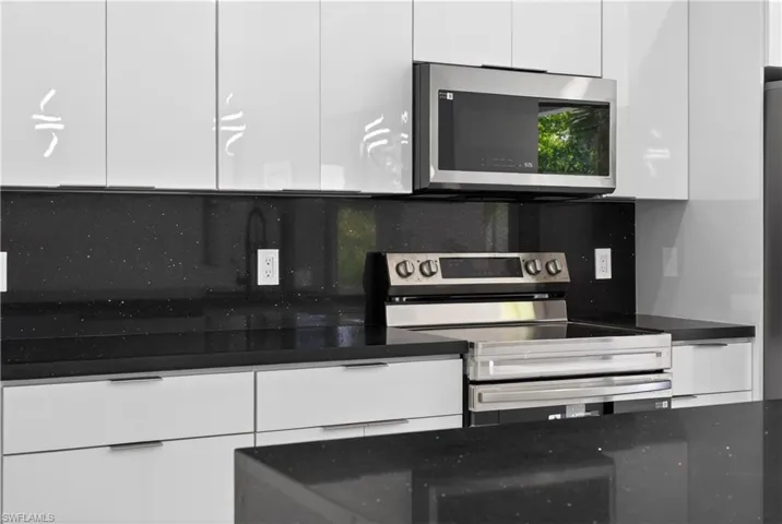 Kitchen view of dark stone countertops and decorative light fixtures