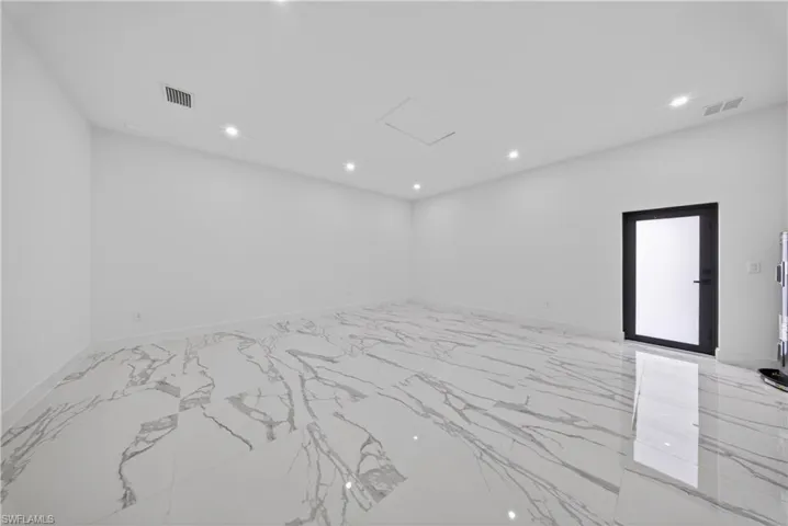 Empty room featuring a ceiling fan and light marble finish flooring