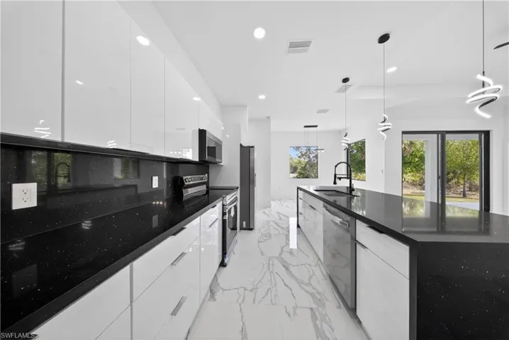 Kitchen featuring white cabinetry, stainless steel appliances, and modern cabinets