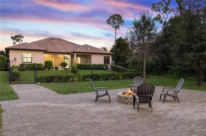 View of front of home with a patio area, an outdoor fire pit, and a yard