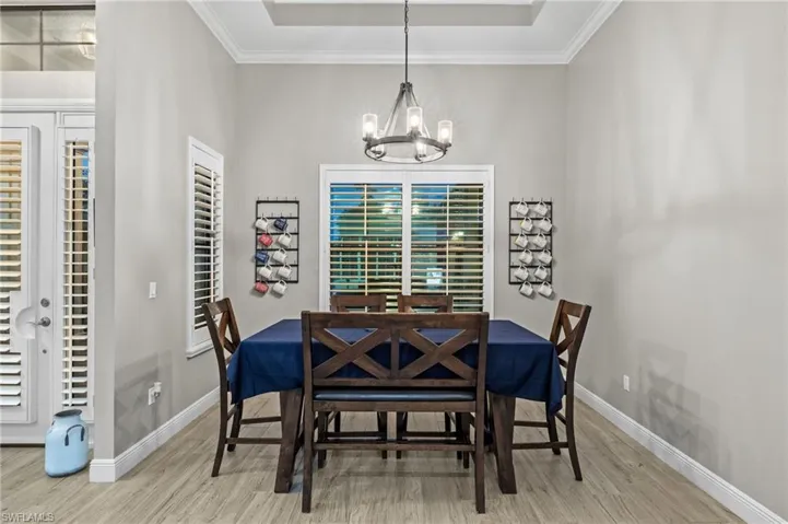 Dining area featuring a notable chandelier, light hardwood / wood-style flooring, and ornamental molding