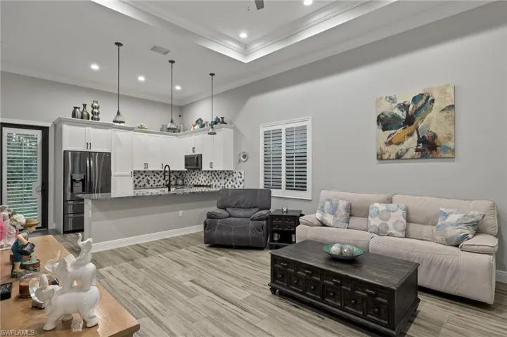 Living room with light hardwood / wood-style floors, sink, and crown molding