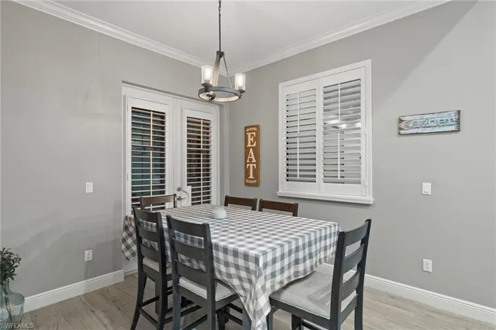 Dining space featuring crown molding, light hardwood / wood-style floors, and a chandelier