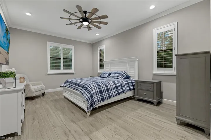 Bedroom featuring multiple windows, light wood-type flooring, and ceiling fan