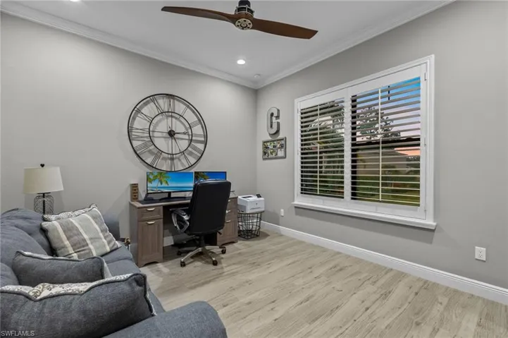 Office with light wood-type flooring, crown molding, and ceiling fan