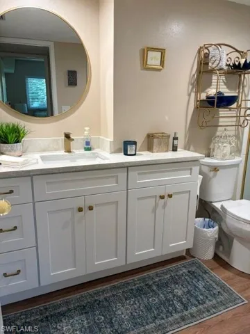 Bathroom vanity featuring a rectangular undermount sink, a gold-toned faucet, and a quartz-finish countertop