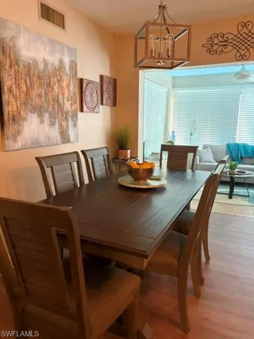 Dining area featuring wood-finish flooring and a contemporary chandelier