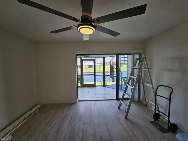 Living room with ceiling fan and light / wood-style flooring