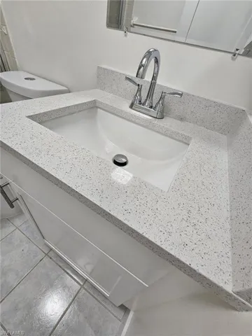 Details featuring toilet, vanity, and tile patterned floors