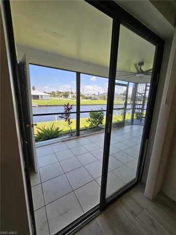 Doorway featuring a wealth of natural light, ceiling fan, and a water view