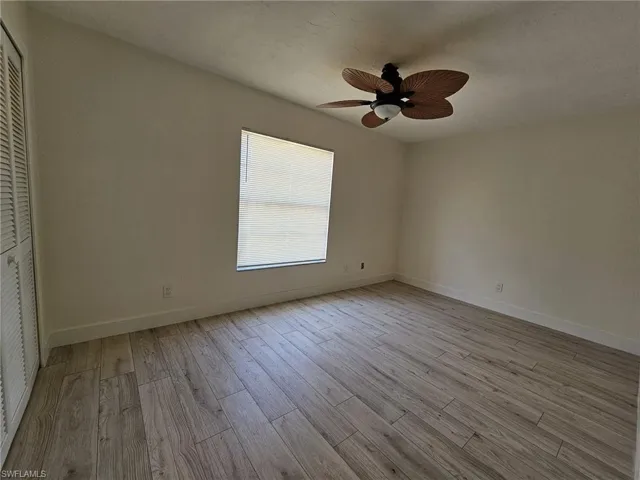 Guest bedroom featuring ceiling fan, light hardwood / wood-style flooring, and a closet
