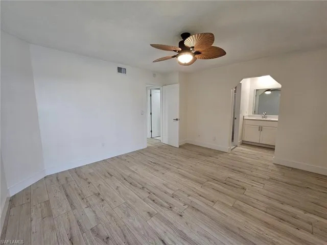 Empty room with light hardwood / wood-style floors and ceiling fan