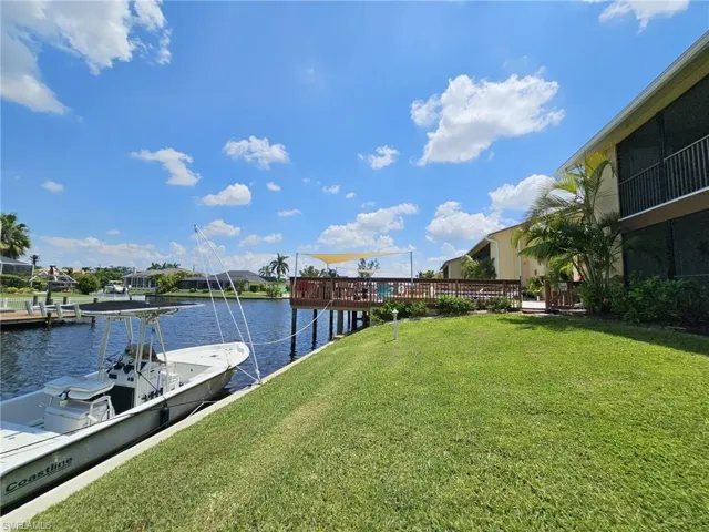 View of dock featuring a yard and a water view