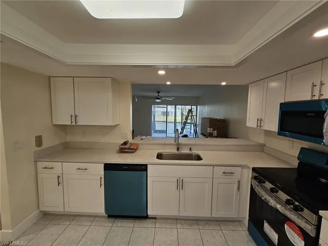 Kitchen with ceiling fan, range with electric cooktop, white cabinets, dishwasher, and sink