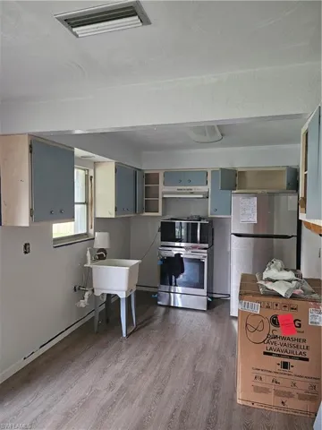Kitchen featuring oven, dark hardwood / wood-style flooring, fridge, and range