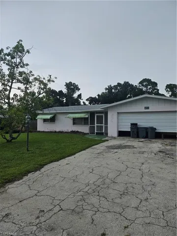 Single story home with a garage and a front yard