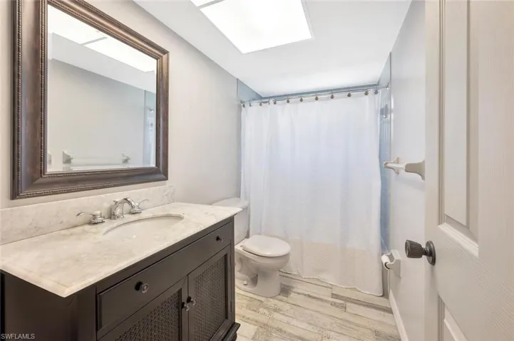 Bathroom featuring wood-type flooring, vanity, and toilet