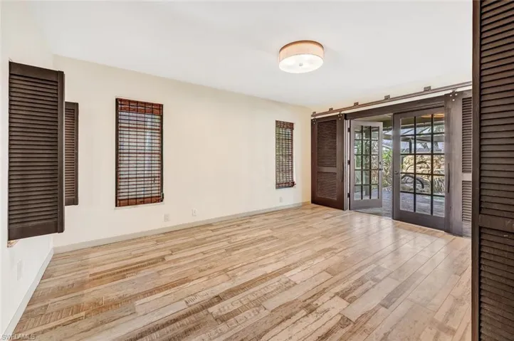 Unfurnished room featuring french doors and light wood-type flooring