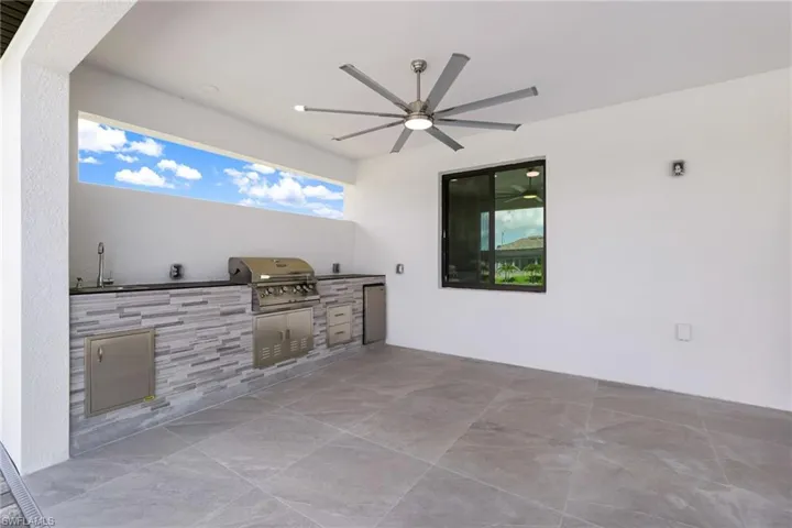 View of patio / terrace with grilling area, exterior kitchen, and ceiling fan