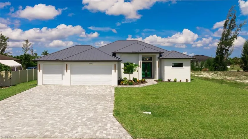 View of front of property with a 3-car garage and a front yard