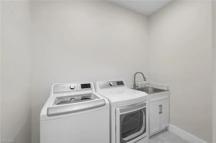 Laundry room with washer and dryer, and laundry tub