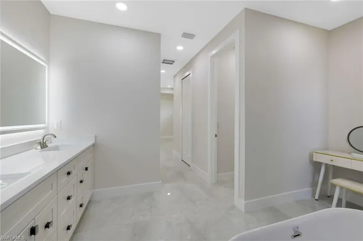 Bathroom with a bathtub, tile flooring, and vanity with extensive cabinet space