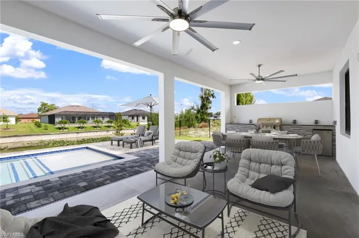View of terrace with ceiling fan, a grill, and an outdoor kitchen