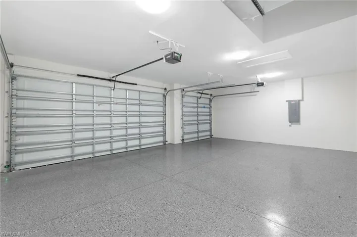Garage featuring a 3-car garage door, and epoxy floors