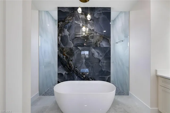 Bathroom featuring tile floors, tile walls, and vanity