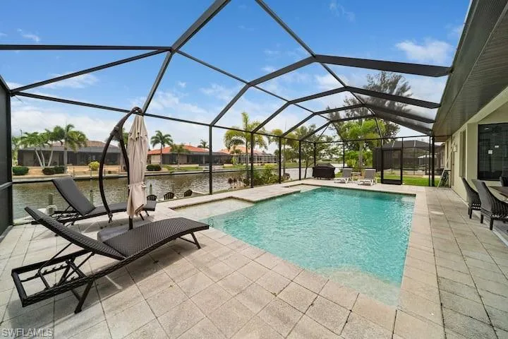 View of pool with a water view, a patio, and a lanai
