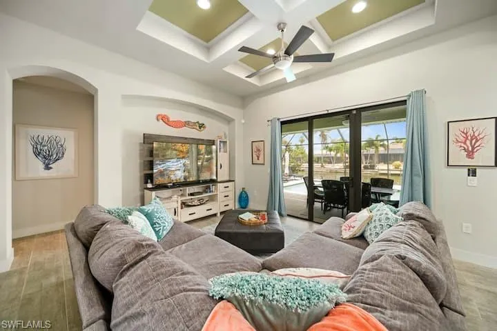 Living room featuring beamed ceiling, coffered ceiling, ceiling fan, and light hardwood / wood-style flooring