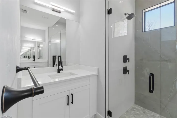 Bathroom featuring vanity and a shower stall