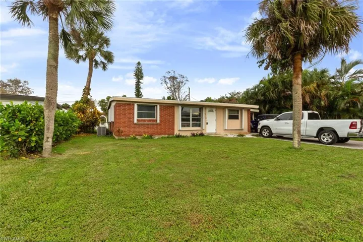 View of front of property featuring a front yard and central air condition unit