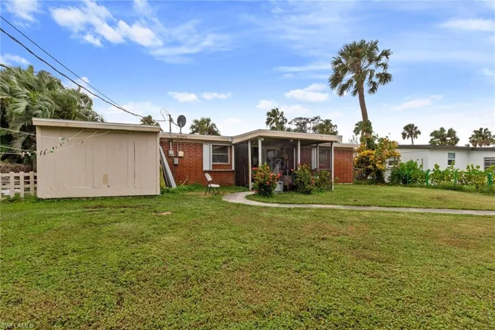View of front of home with a front lawn and a sunroom