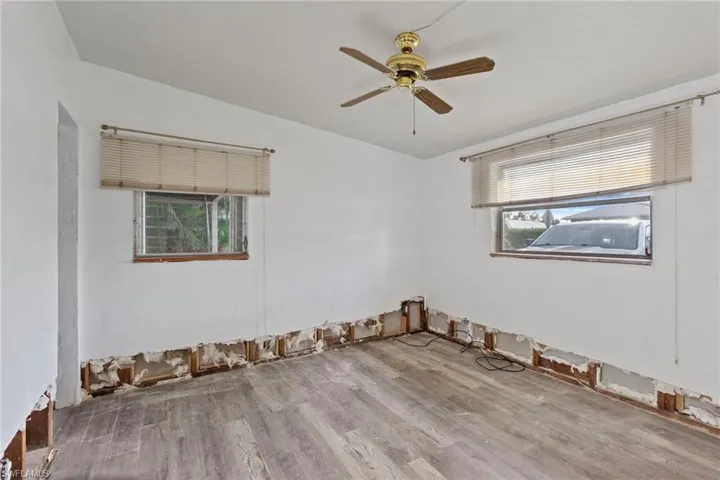 Empty room with ceiling fan, a healthy amount of sunlight, and light hardwood / wood-style flooring