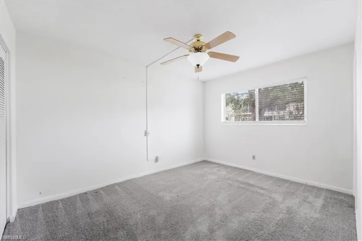 Unfurnished room featuring carpet flooring and ceiling fan