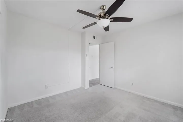 Spare room featuring carpet and ceiling fan