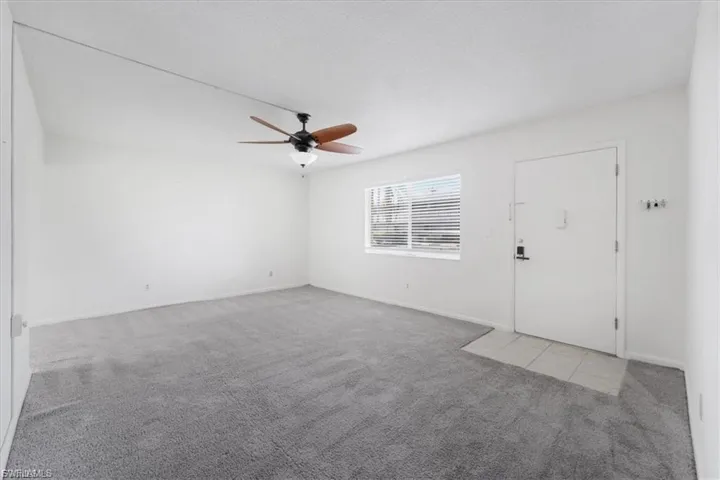 Unfurnished living room featuring light colored carpet and ceiling fan
