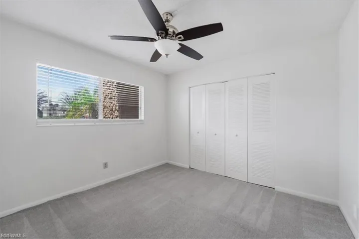 Unfurnished bedroom featuring carpet, ceiling fan, and a closet
