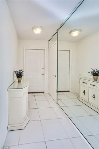 Entryway with light tile patterned flooring and baseboards
