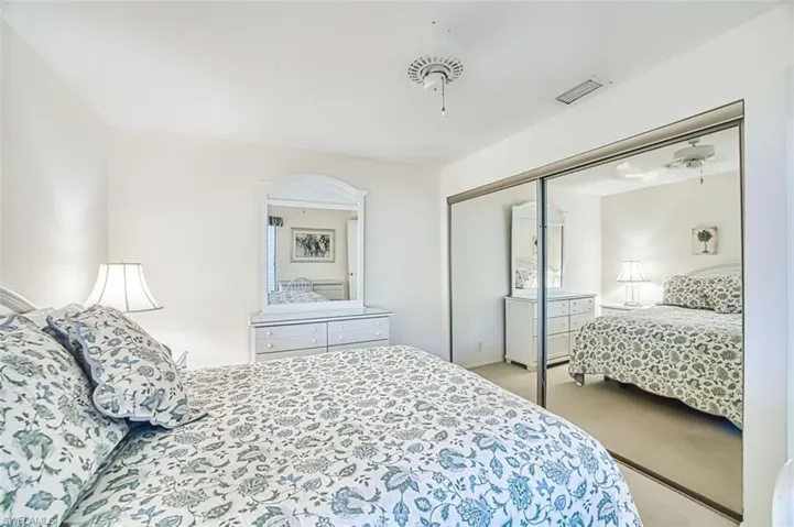 Bedroom with light colored carpet and a closet