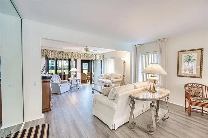 Living area with light wood-style floors and a ceiling fan