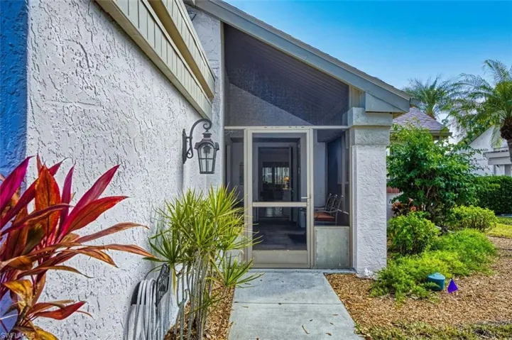 Property entrance with a sunroom and stucco siding