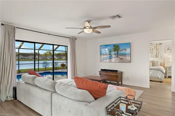 Living room with a water view, ceiling fan, and light hardwood / wood-style flooring