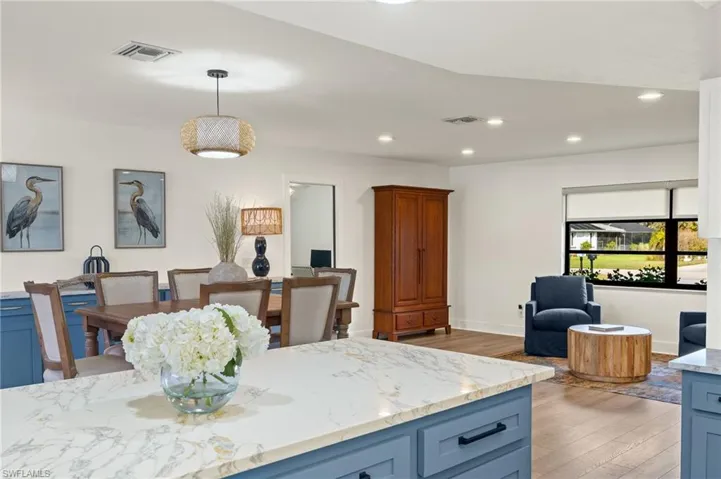 Kitchen featuring light stone counters, light hardwood / wood-style flooring, and pendant lighting