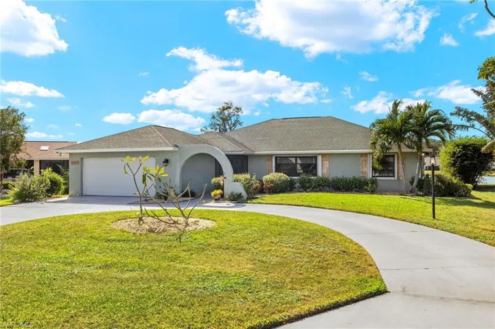 Ranch-style house with a garage and a front lawn