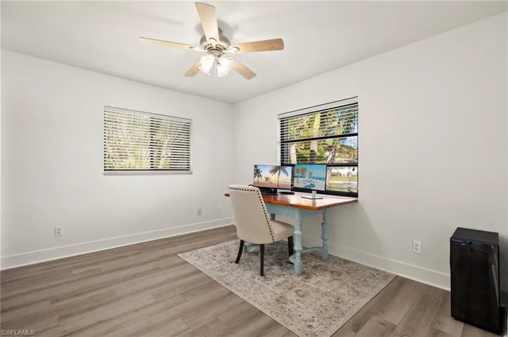 Home office with ceiling fan and wood-type flooring