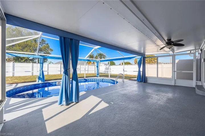 View of pool featuring glass enclosure, a sunroom, a patio, and a fenced backyard